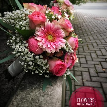 Blumenstrauß liegt seitlich auf einer Betonwand