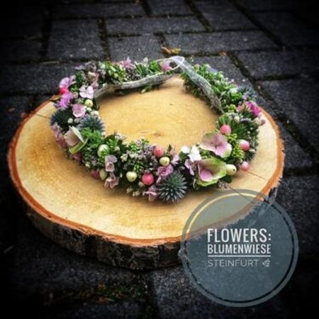 Blumenschmuck auf einer Holzscheibe