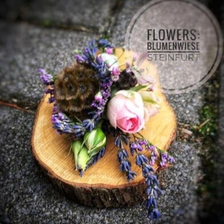 Blumenschmuck auf einer Holzscheibe